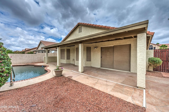 back of property featuring stucco siding, a patio, a fenced backyard, and a tiled roof