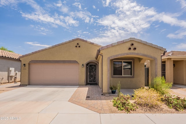 1755 E Mesquite Ave, Apache Junction, AZ 85119 - mediterranean / spanish-style house featuring an attached garage, stucco siding, driveway, and a tiled roof