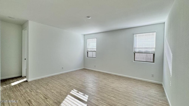 empty room featuring light wood-style flooring and baseboards