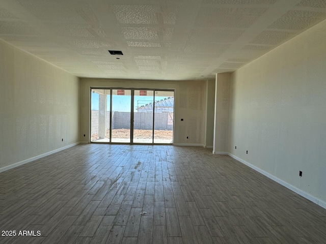 empty room with dark wood-style floors and baseboards