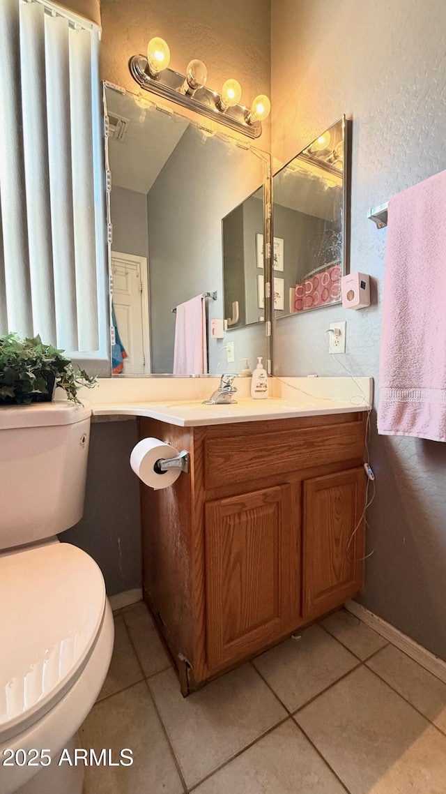 bathroom featuring tile patterned flooring, vanity, and toilet