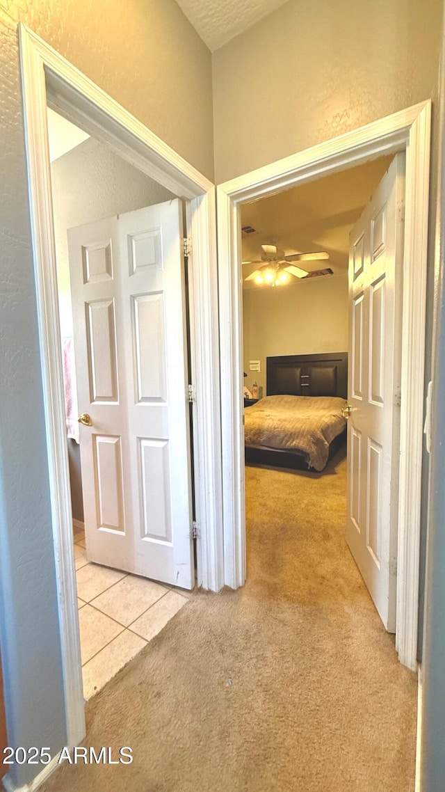 hall with light colored carpet