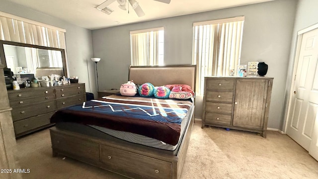 bedroom with multiple windows, light colored carpet, and ceiling fan