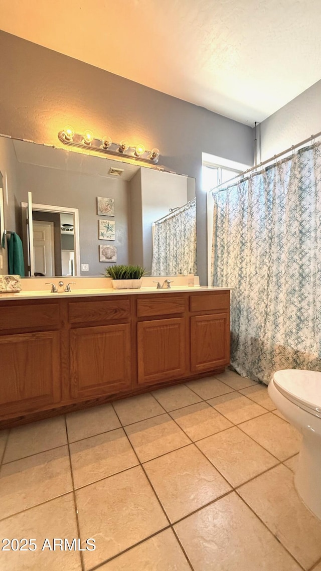 bathroom featuring tile patterned flooring, vanity, and toilet