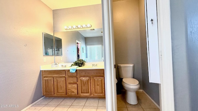 bathroom featuring tile patterned flooring, vanity, and toilet