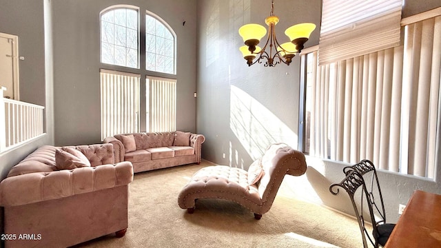 living room featuring carpet flooring, a chandelier, and a towering ceiling