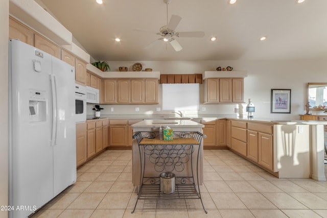 kitchen featuring kitchen peninsula, light brown cabinets, a kitchen island, and white appliances