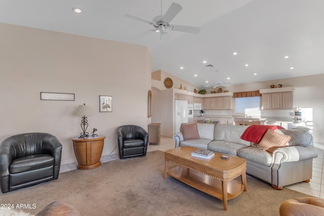 carpeted living room with ceiling fan, sink, and high vaulted ceiling