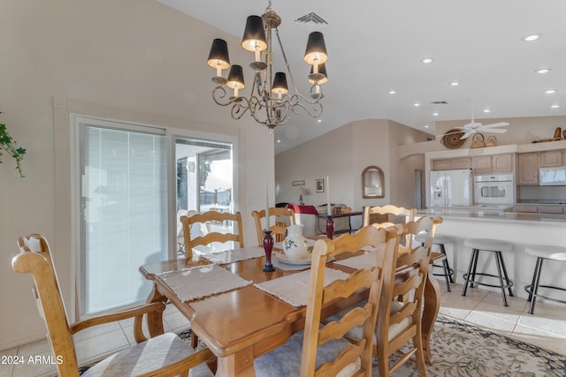 dining area featuring ceiling fan with notable chandelier, light tile patterned floors, and vaulted ceiling