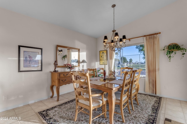 dining space featuring light tile patterned floors, vaulted ceiling, and an inviting chandelier