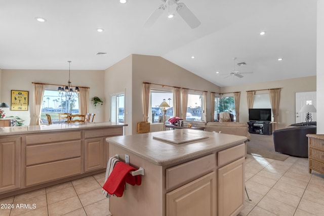 kitchen with light tile patterned floors, vaulted ceiling, a kitchen island, and plenty of natural light