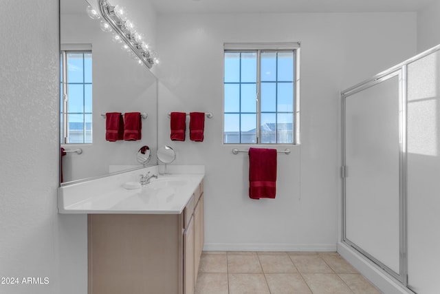 bathroom with an enclosed shower, vanity, tile patterned floors, and a wealth of natural light