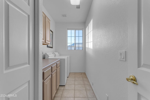 laundry area with washer and dryer, cabinets, and light tile patterned floors