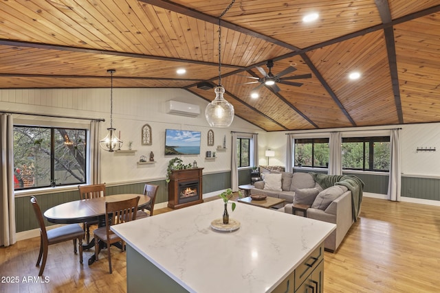 kitchen featuring wooden ceiling, a wall unit AC, a lit fireplace, light wood finished floors, and beam ceiling