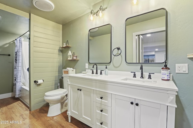 full bathroom featuring toilet, wood finished floors, double vanity, a textured wall, and shower / bath combo