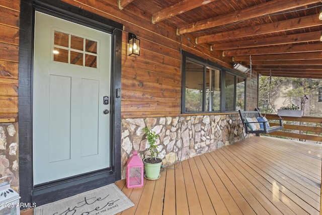 property entrance featuring stone siding and covered porch