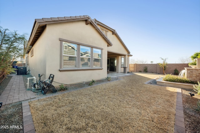 rear view of property featuring cooling unit and a patio