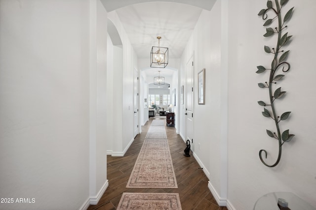 corridor featuring dark hardwood / wood-style floors and a notable chandelier