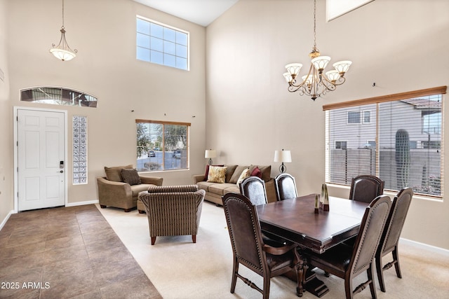 tiled dining space featuring a towering ceiling and an inviting chandelier