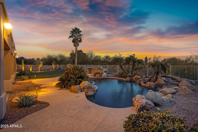 pool at dusk with a patio area