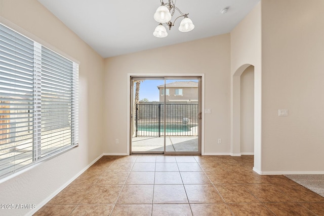 interior space featuring an inviting chandelier, vaulted ceiling, and light tile patterned flooring