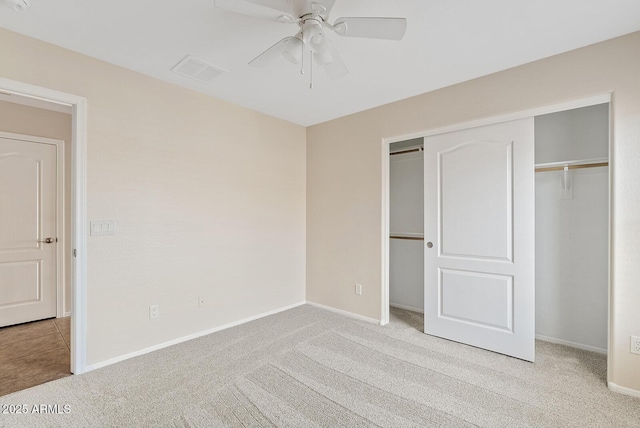 unfurnished bedroom with ceiling fan, a closet, and light carpet