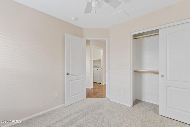 unfurnished bedroom featuring ceiling fan, light colored carpet, washer / dryer, and a closet