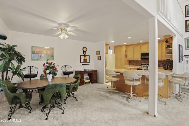 dining room featuring light carpet, a ceiling fan, and recessed lighting