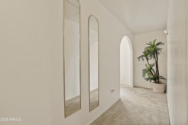 hallway featuring carpet and arched walkways