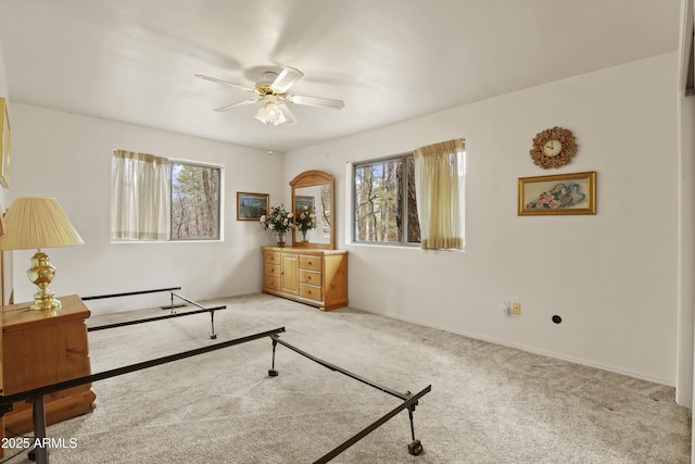 living area featuring light carpet, a healthy amount of sunlight, and ceiling fan