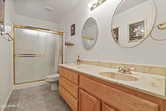 bathroom featuring visible vents, toilet, vanity, and a shower with door