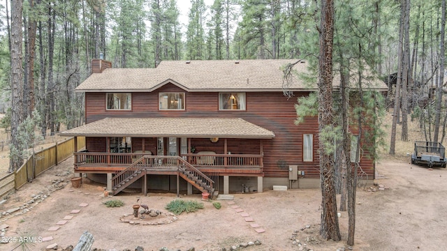 view of front of property featuring a shingled roof, driveway, a chimney, and stairs