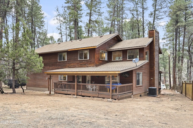 back of house with a chimney, roof with shingles, crawl space, fence, and a wooden deck