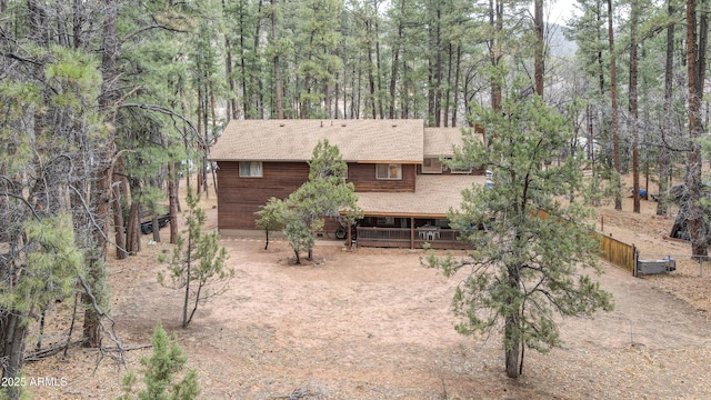 back of house featuring fence and dirt driveway