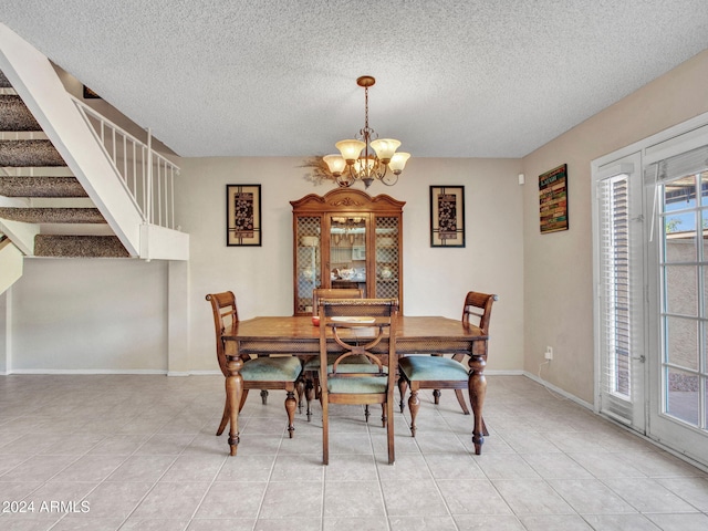 tiled dining space featuring a textured ceiling and a chandelier