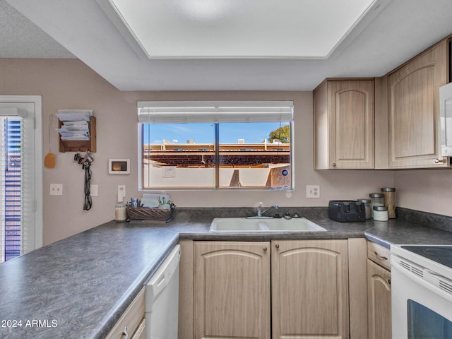 kitchen with white appliances, sink, and light brown cabinets