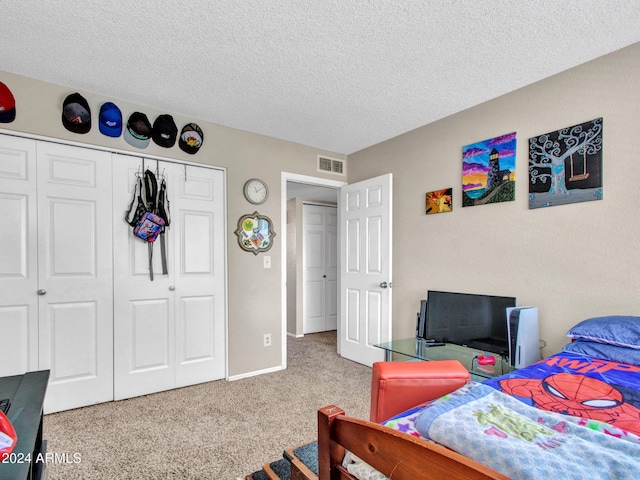 carpeted bedroom featuring a closet and a textured ceiling