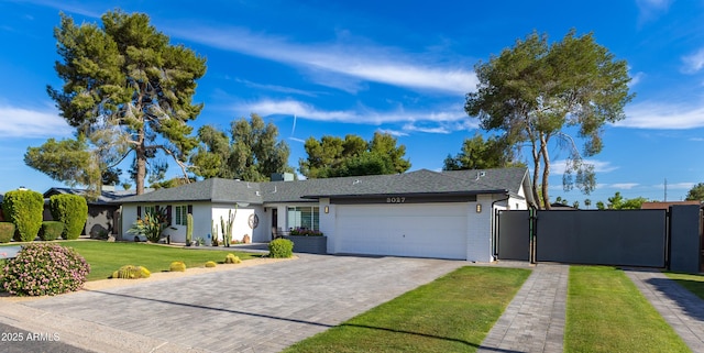 ranch-style house with decorative driveway, a front lawn, a gate, and an attached garage