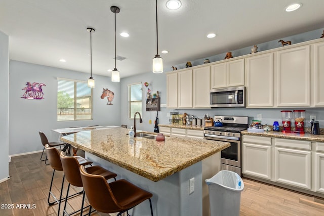 5218 W Lydia Ln, Laveen, AZ 85339 - kitchen featuring recessed lighting, an island with sink, light wood-style floors, stainless steel appliances, and a sink