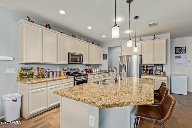 5218 W Lydia Ln, Laveen, AZ 85339 - kitchen featuring visible vents, a sink, a center island with sink, light wood-style flooring, and stainless steel appliances