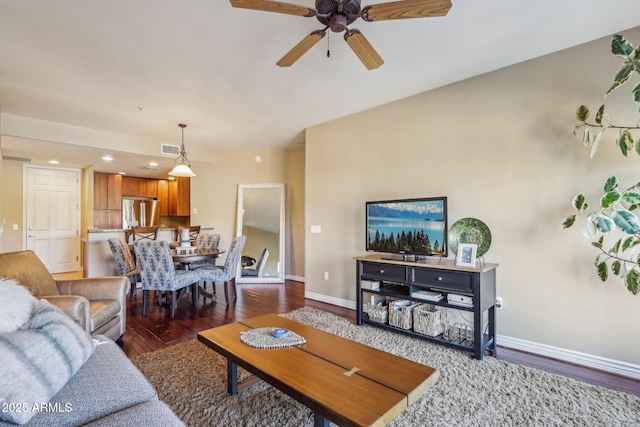 living room featuring ceiling fan and dark hardwood / wood-style flooring