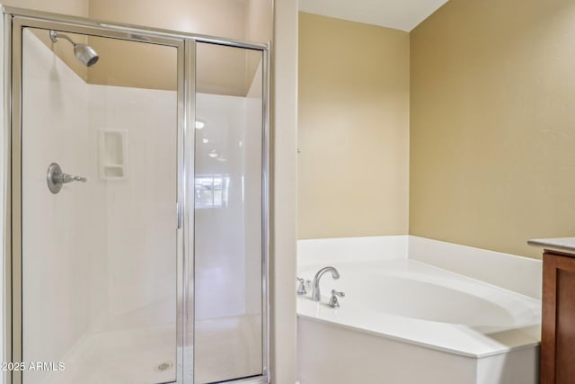 bathroom with vanity and shower with separate bathtub