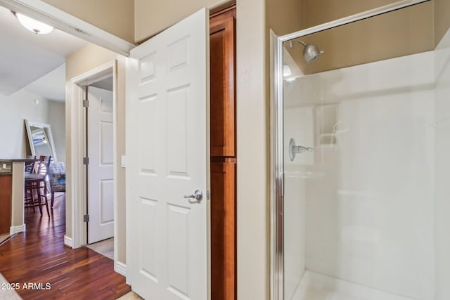 bathroom featuring wood-type flooring and an enclosed shower