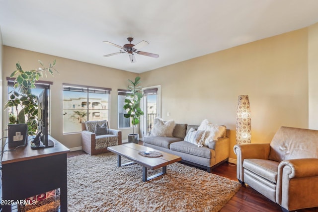 living room with dark wood-type flooring and ceiling fan