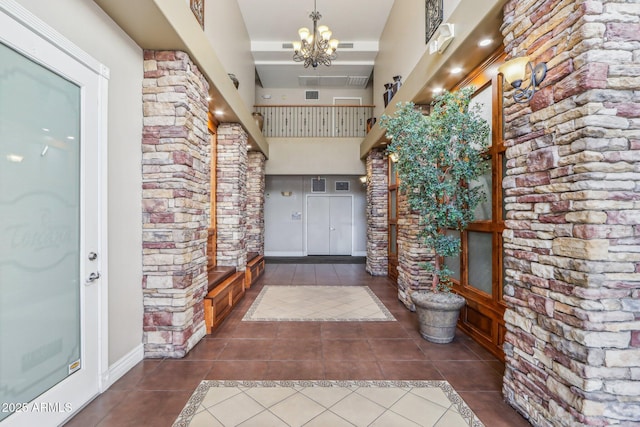 hall with dark tile patterned flooring and a notable chandelier