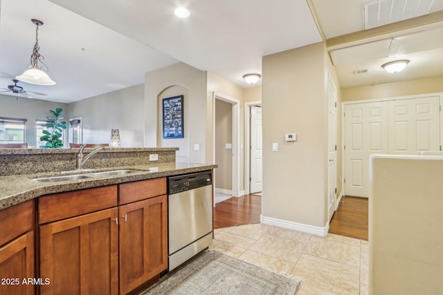 kitchen featuring pendant lighting, sink, light tile patterned floors, ceiling fan, and stainless steel dishwasher