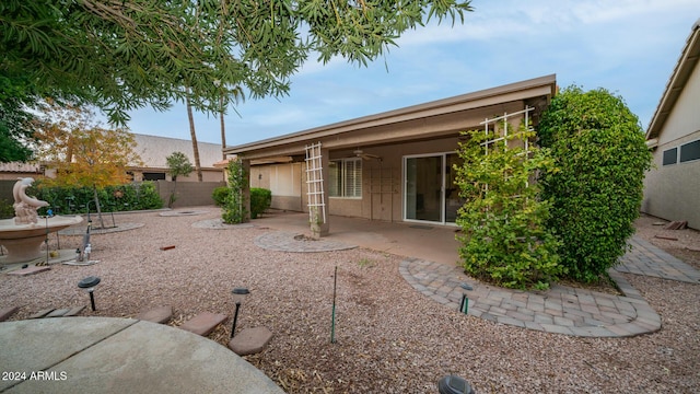 rear view of property with ceiling fan and a patio area