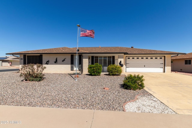 ranch-style home with brick siding, driveway, a shingled roof, and an attached garage