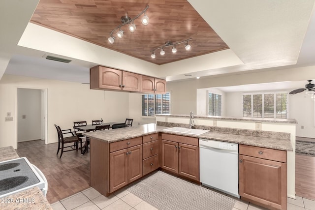 kitchen with light countertops, a sink, a tray ceiling, and white appliances