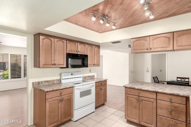 kitchen featuring light countertops, white electric range, black microwave, a tray ceiling, and light tile patterned floors